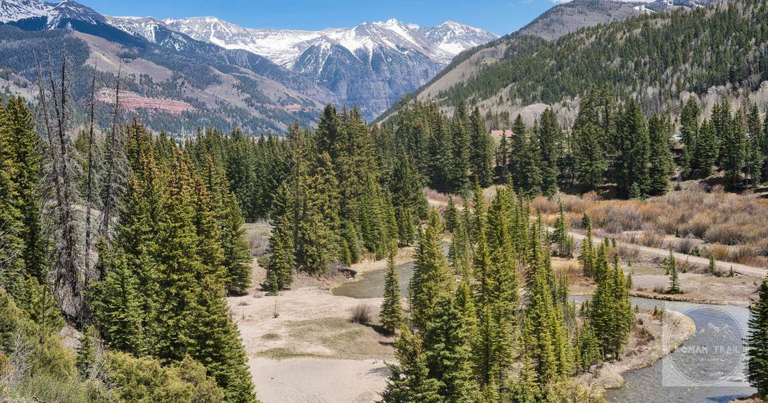 The San Juan Mountains above Telluride with forest and a river below, the range that closes the valley at both ends.