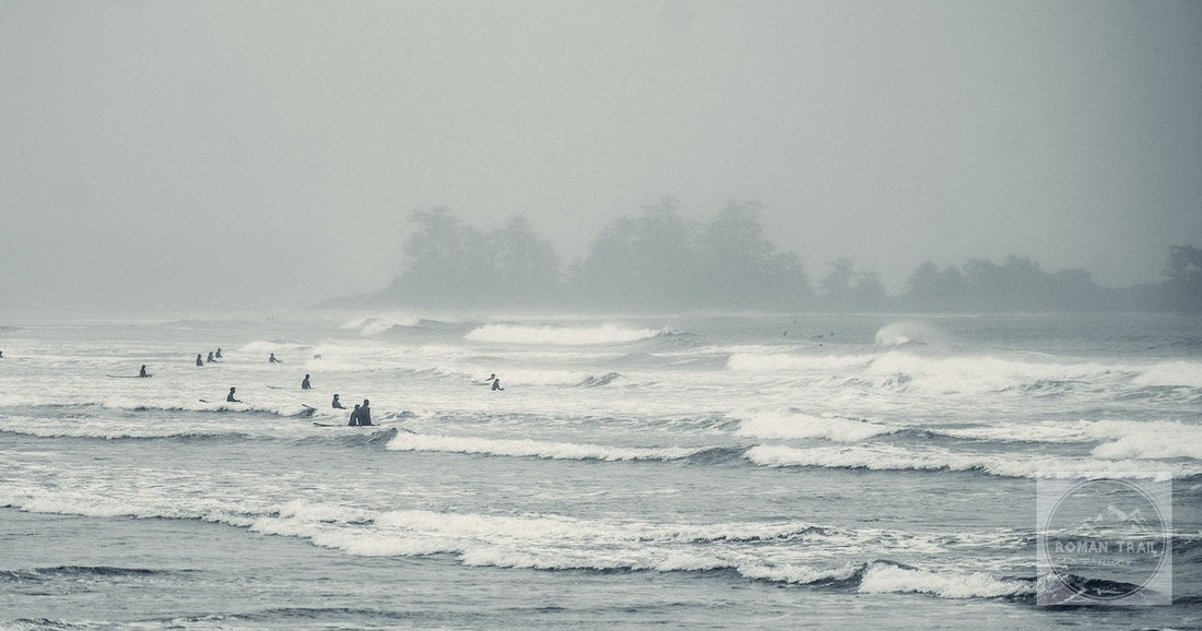 Surfers in misty waves at Tofino, British Columbia