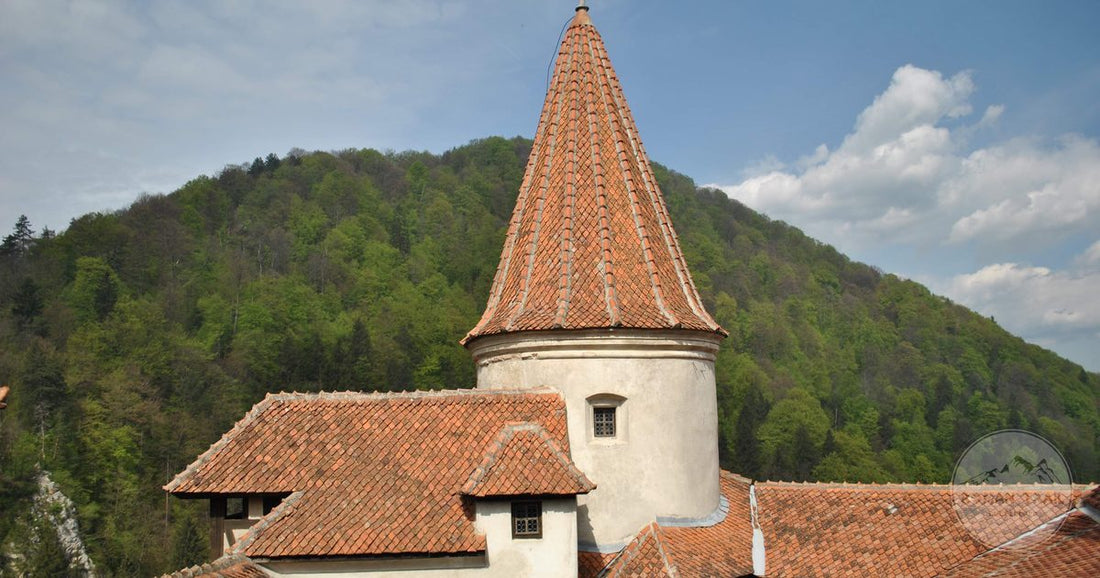 A tower of Bran Castle above green hills in Transylvania, Romania