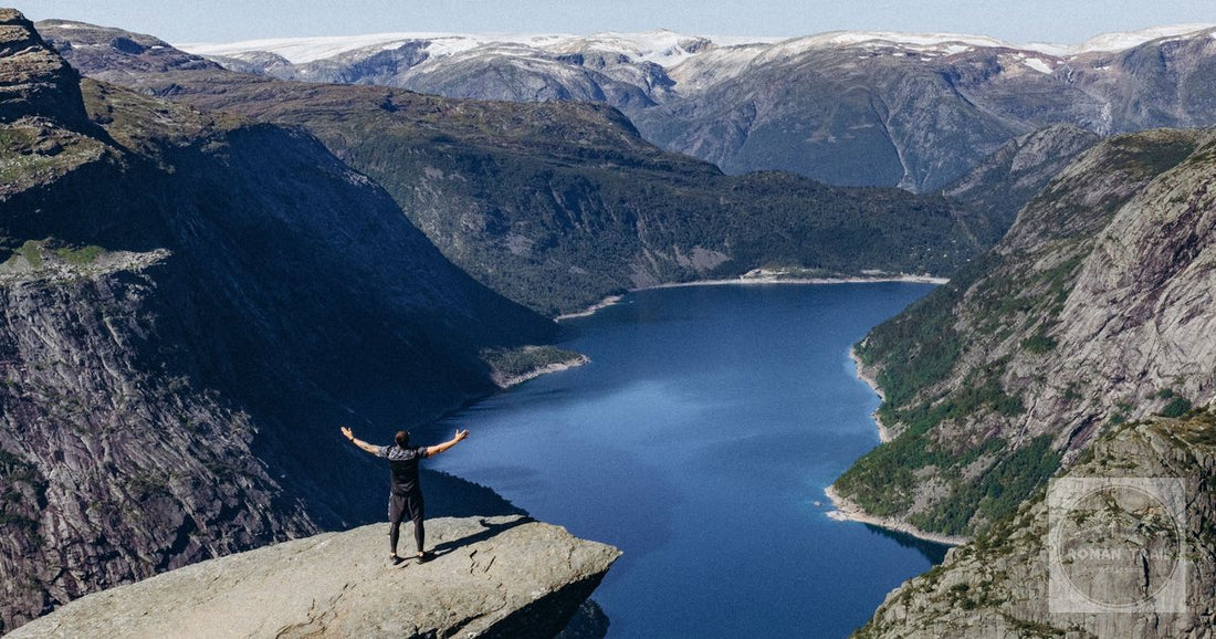 A lone hiker standing on the Trolltunga rock above the fjord, Norway