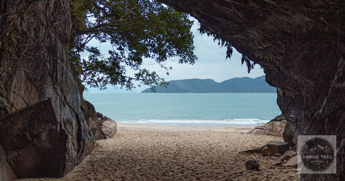 Picturesque view of the Ubatuba beach from within a natural cave, showcasing a serene seascape.