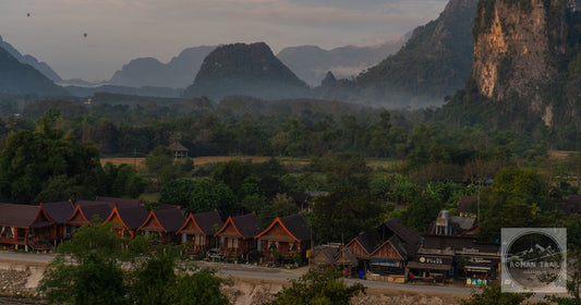 Huts below the karst mountains in mist at Vang Vieng, Laos