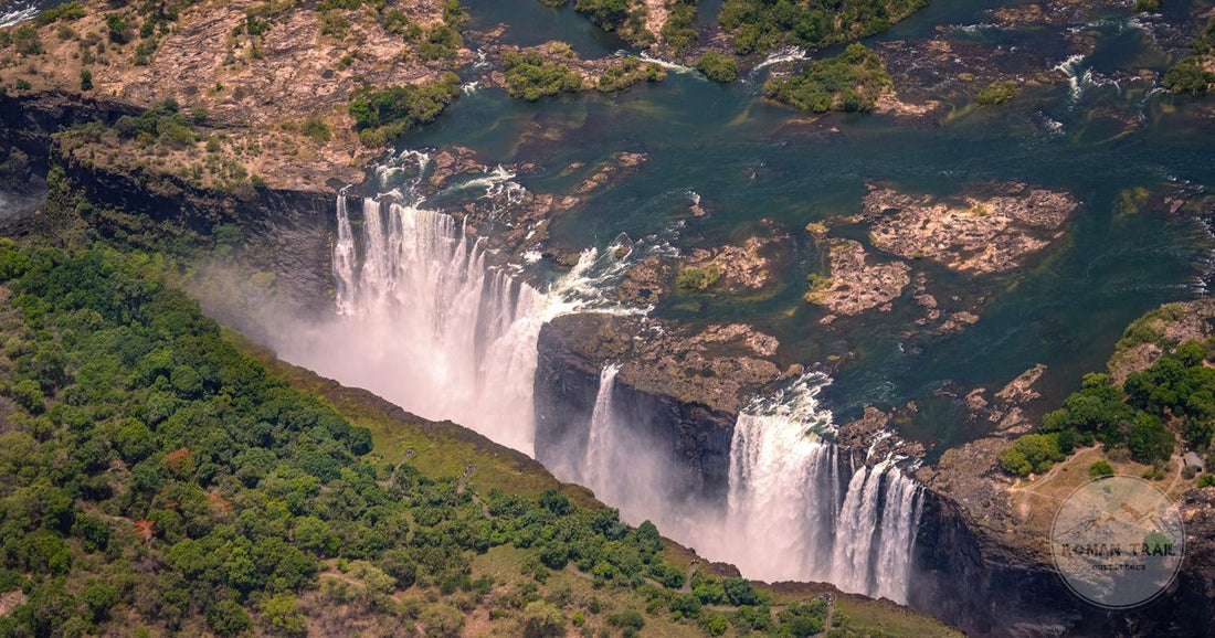 Aerial view of Victoria Falls surrounded by greenery, Zambezi river