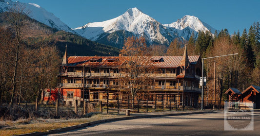 A historical wooden building against snow-capped mountains in Zdiar, Slovakia