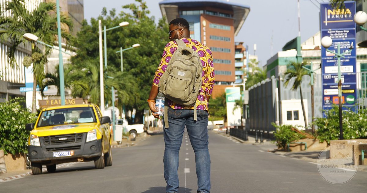 A man standing on a city street looking out over Abidjan, Ivory Coast