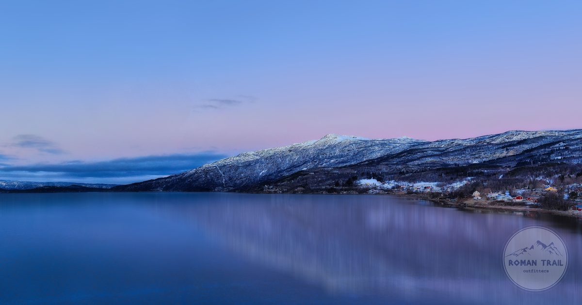 A frozen lake at dawn below snow covered mountains at Abisko, Sweden