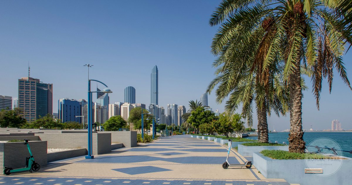 The Abu Dhabi skyline seen from the Corniche with palm trees, UAE