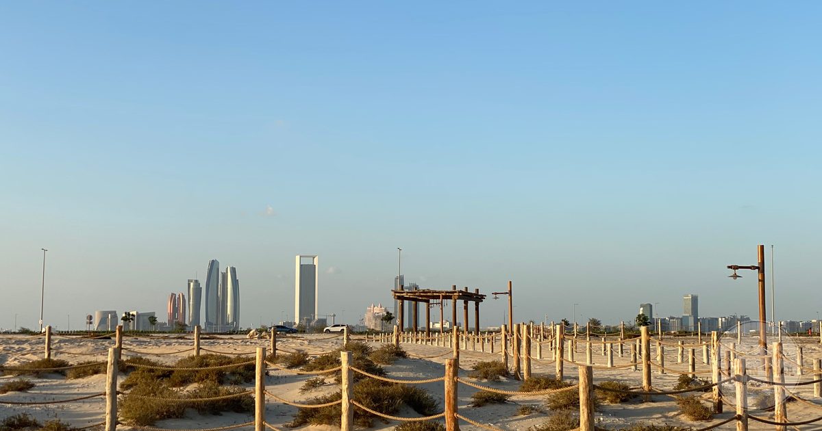 Desert landscape with the Abu Dhabi skyline behind, UAE