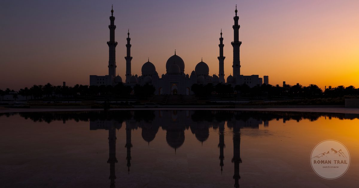 The Sheikh Zayed Grand Mosque reflected in water at sunset, Abu Dhabi, UAE