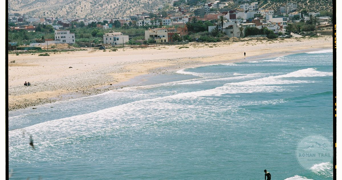 A surfer riding a wave along the Atlantic coast near Agadir, Agadir packing list for women by Roman Trail Outfitters