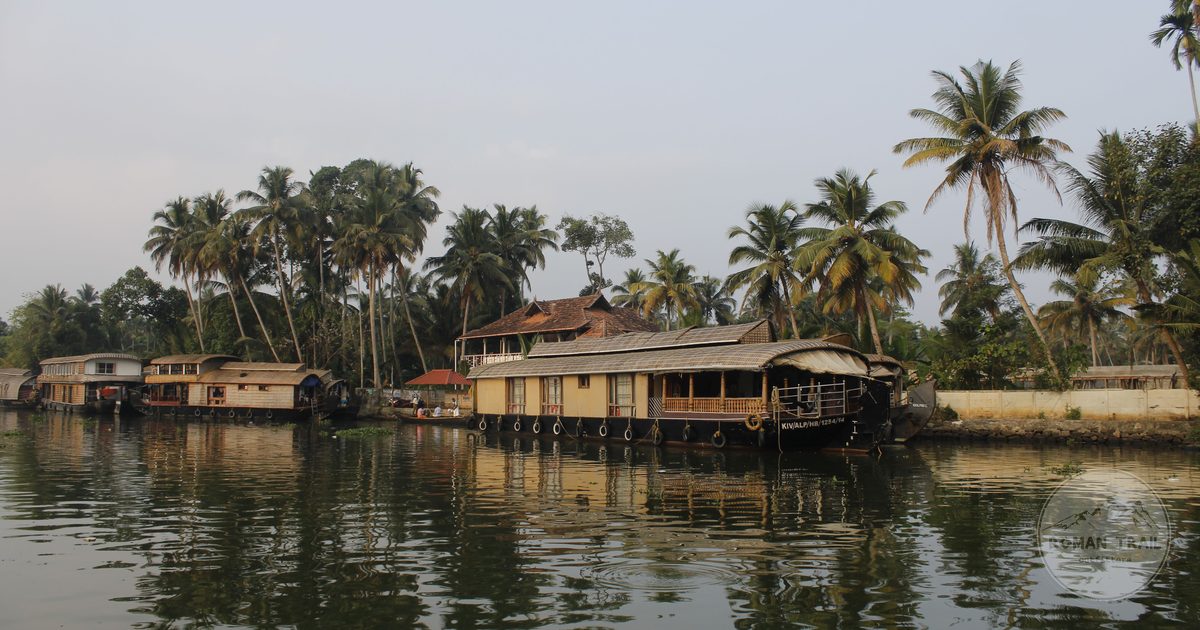Kerala backwaters at sunrise with houseboats and palm trees, Alleppey packing list for women by Roman Trail Outfitters