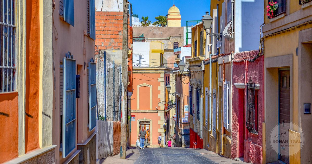 A sunlit street with vibrant buildings in Almeria, Spain