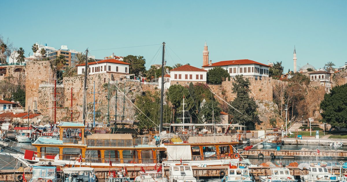 Boats docked at Antalya harbour with historic buildings behind, Turkiye
