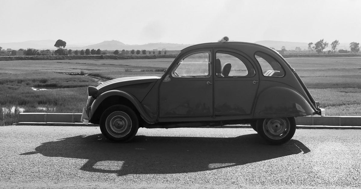 A classic Citroën 2CV parked on a rural road near Antananarivo, Madagascar