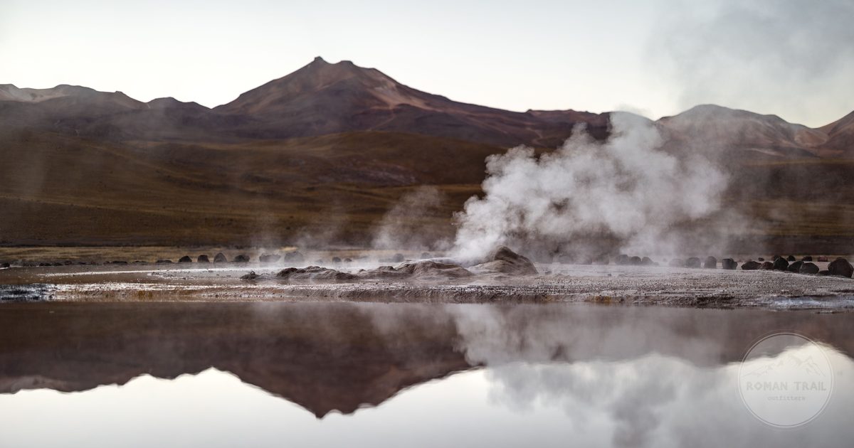 Steam rising from the El Tatio geysers against the mountains, Chile