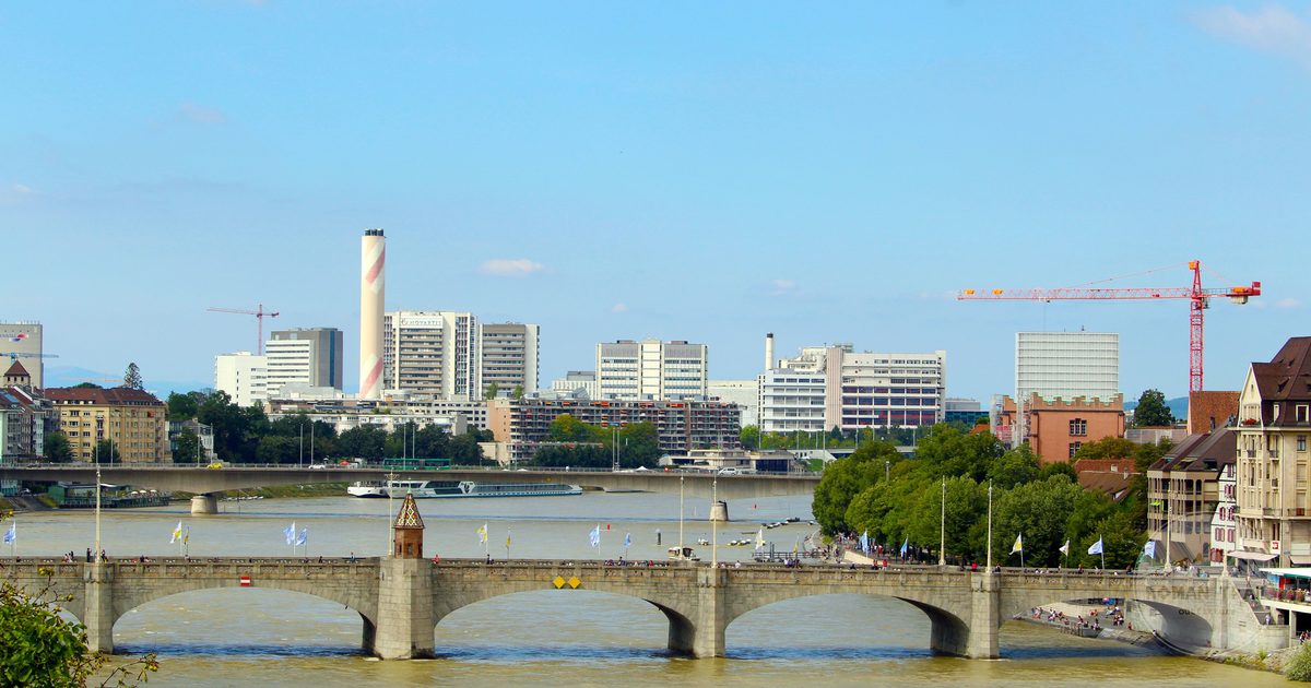 A historic bridge over the Rhine with the Basel skyline behind, Switzerland
