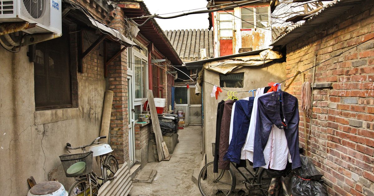 A narrow Beijing hutong alley with bicycles and grey brick courtyard walls, Beijing packing list for women by Roman Trail Outfitters