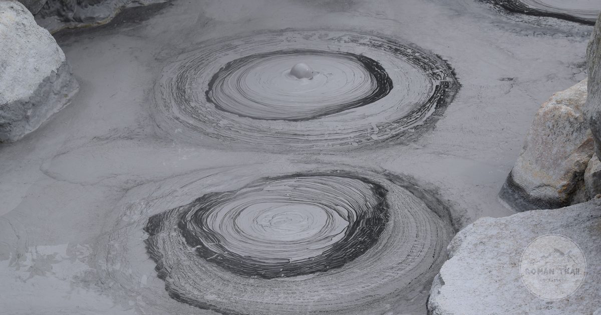 Grey geothermal mud pools with bubbling patterns at Beppu, Japan