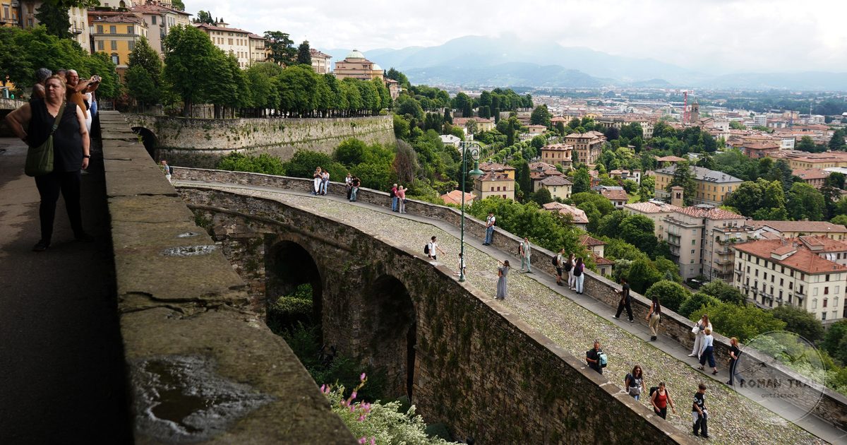 Visitors walking the historic walls of the Citta Alta at Bergamo, Italy