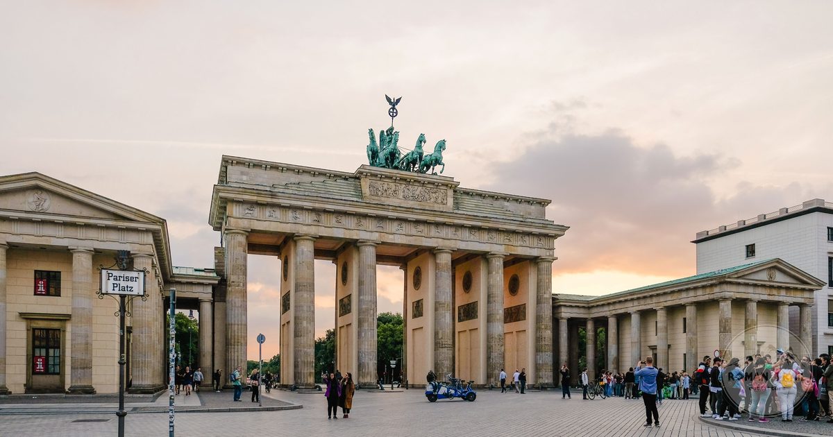 Brandenburg Gate in Berlin with people gathering at dusk, Germany