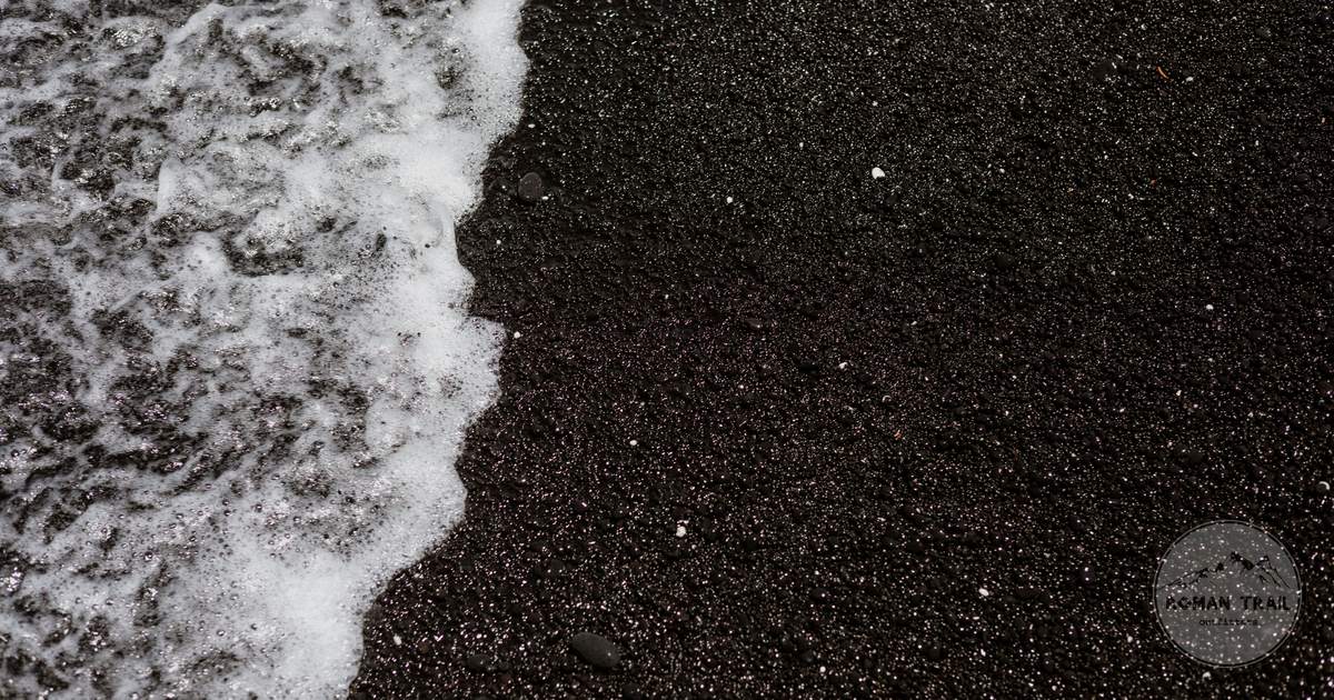Waves washing over a black sand beach at Kailua-Kona, Hawaii