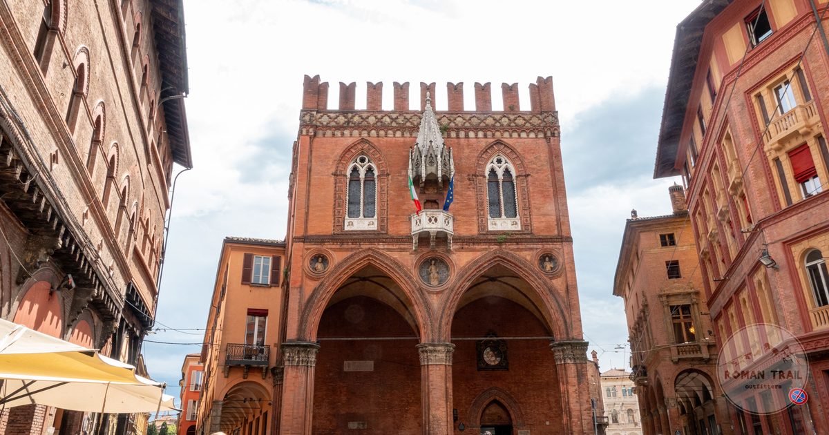 A lively street in front of a historic palazzo in Bologna, Bologna packing list for women by Roman Trail Outfitters