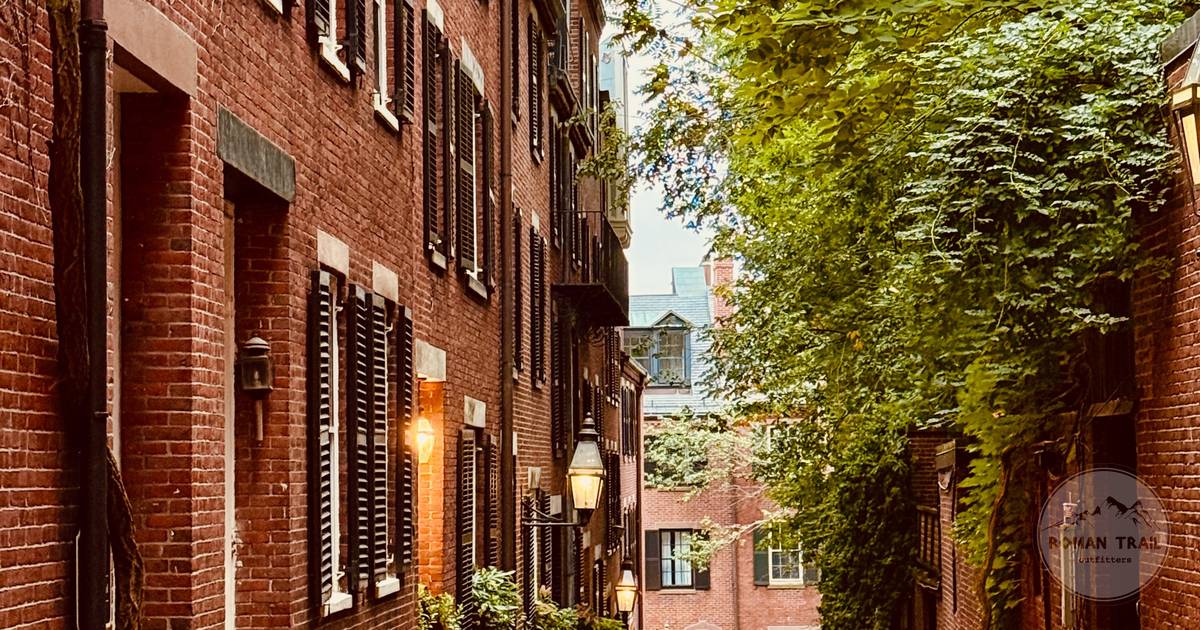 Cobblestone street lined with red brick rowhouses and gas lamps in Beacon Hill, Boston for women travelers