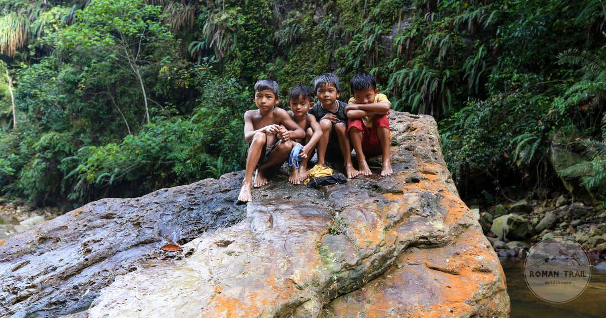 Children on a rock in the jungle of North Sumatra, Indonesia