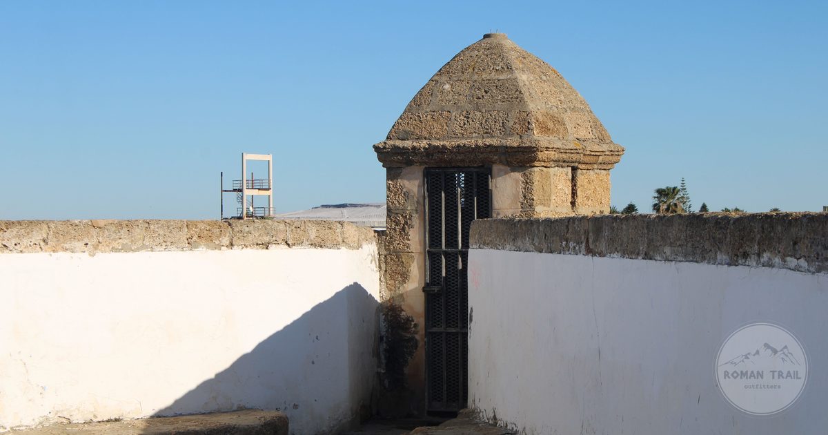 The old fort wall and turret above the sea at Cadiz, Cadiz packing list for women by Roman Trail Outfitters