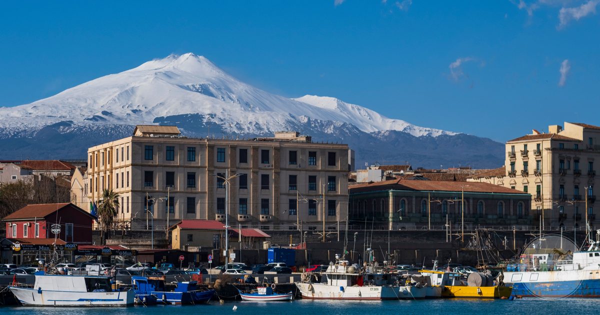 Snow on Mount Etna above the harbour at Catania, Catania packing list for women by Roman Trail Outfitters