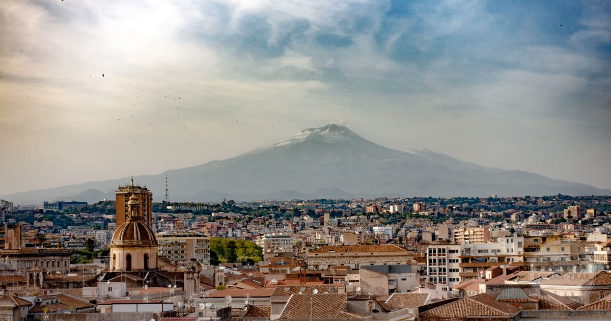 The Catania cityscape with Mount Etna rising behind it, Catania packing list for women by Roman Trail Outfitters