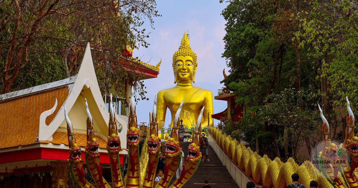 Visitors climbing the stairs to a golden Buddha at a Chiang Mai temple, Thailand