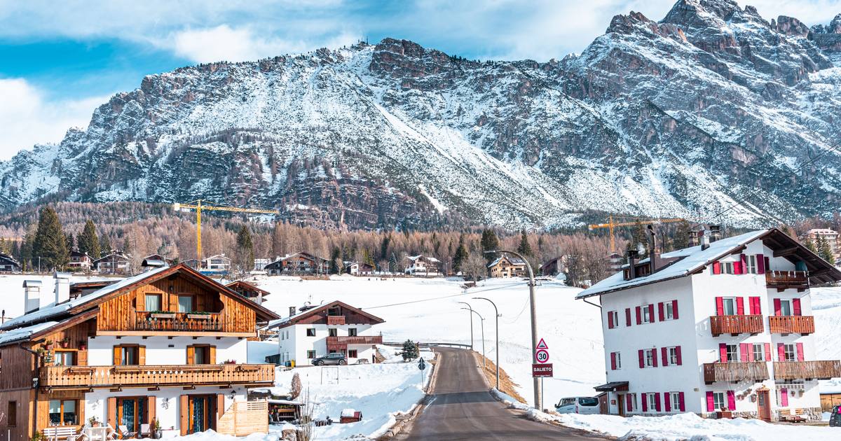 Alpine houses below snowy mountains at Cortina d'Ampezzo, Italy