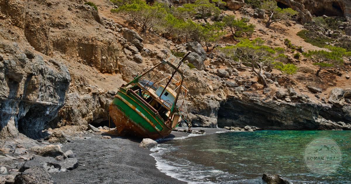 A shipwreck on a dark sand beach at Rethymno, Crete, Greece
