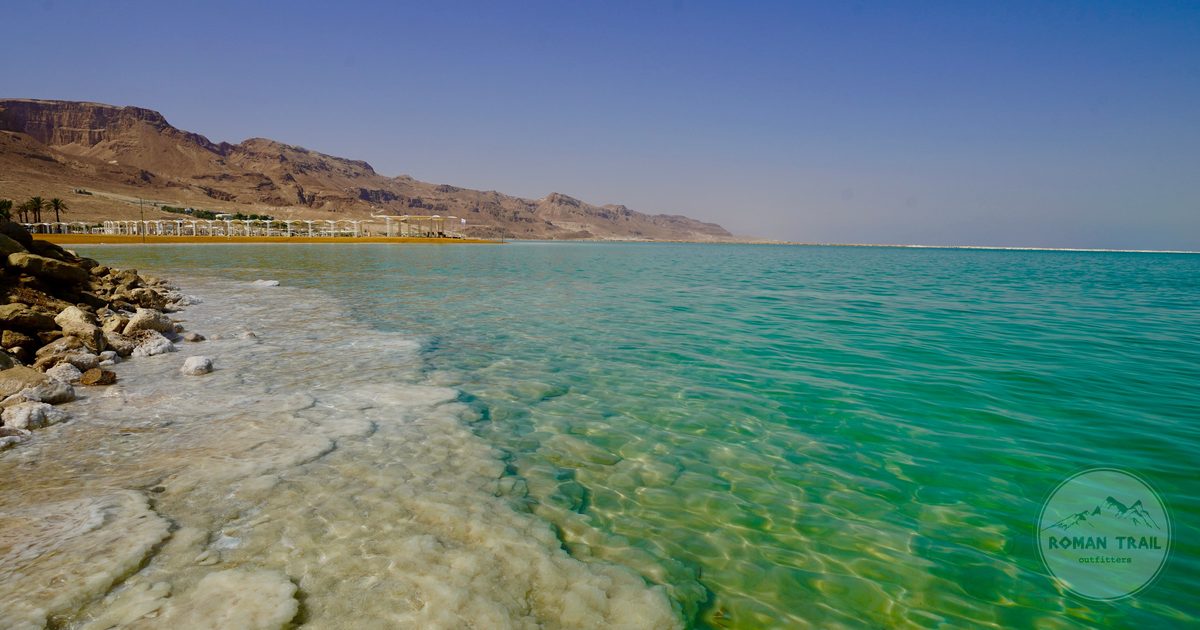 Turquoise water and a salt encrusted shoreline at the Dead Sea, Dead Sea packing list for women by Roman Trail Outfitters