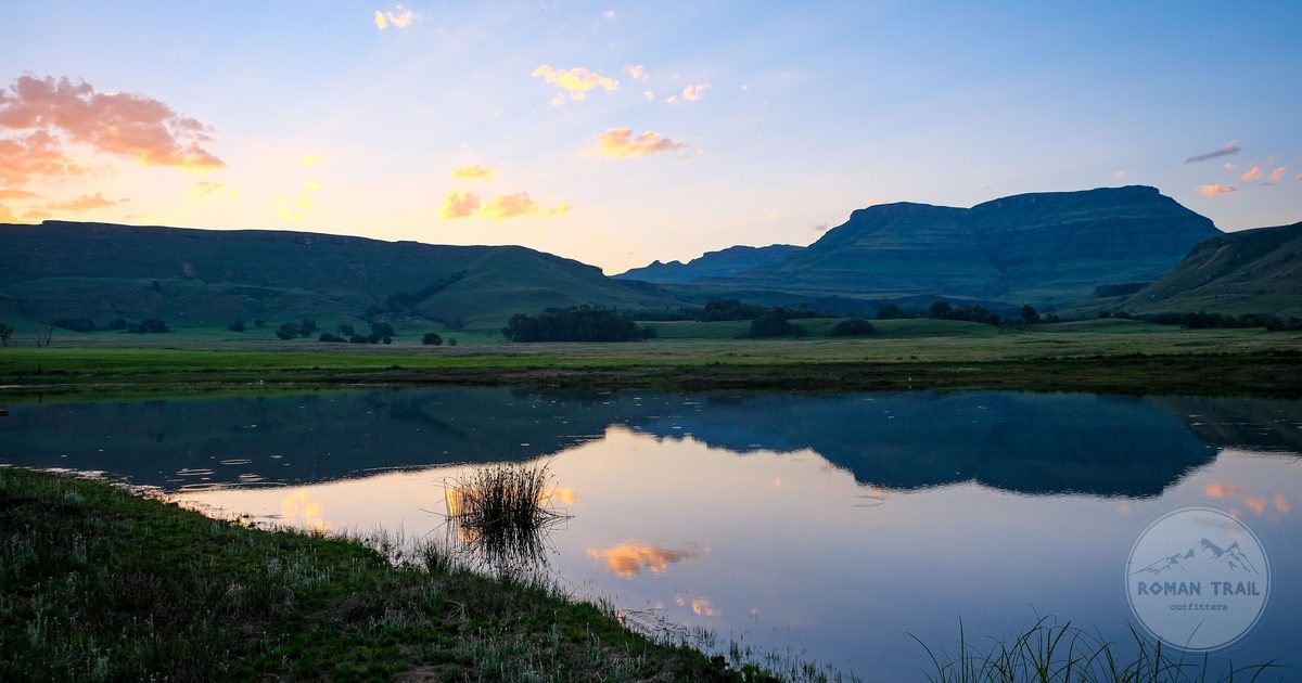 Sunrise over a pond below the Drakensberg mountains at Himeville, South Africa