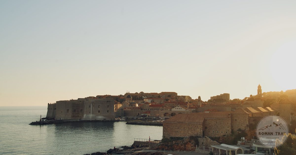 Dubrovnik Old Town and its harbour walls seen across the water in low golden light, Dubrovnik for women travelers