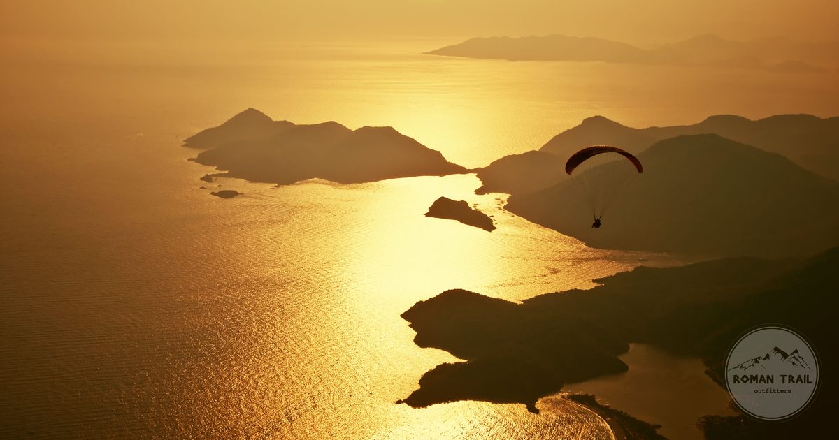 A paraglider over the Oludeniz coast at sunset, Turkiye