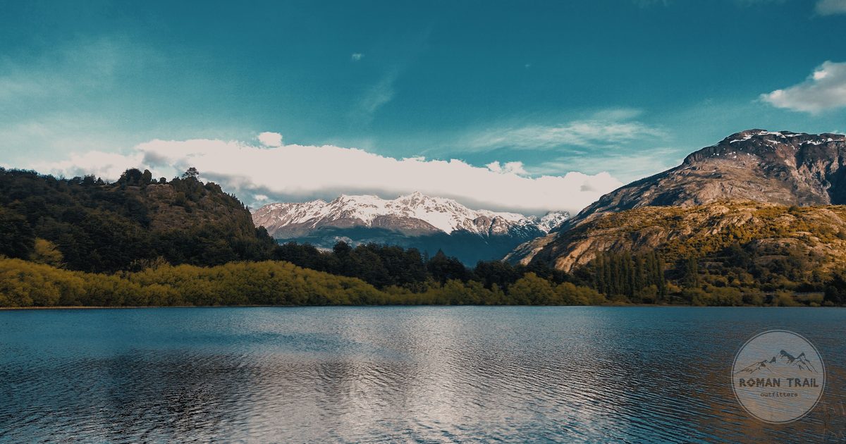 A calm lake below snow capped mountains at Futaleufú, Chile