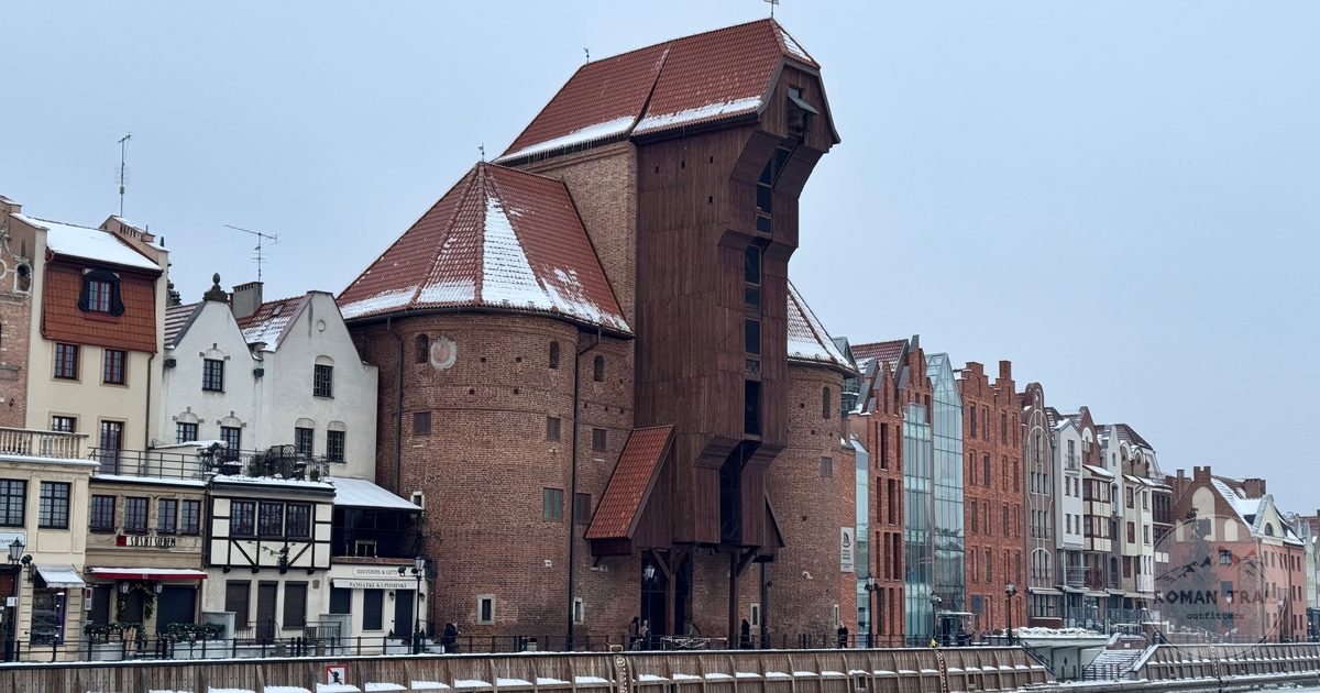 The historic Gdansk Crane covered in winter snow beside the river, Poland