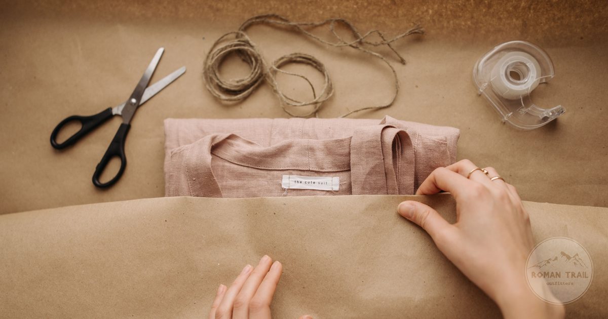Hands wrapping a folded shirt in paper with twine as a gift