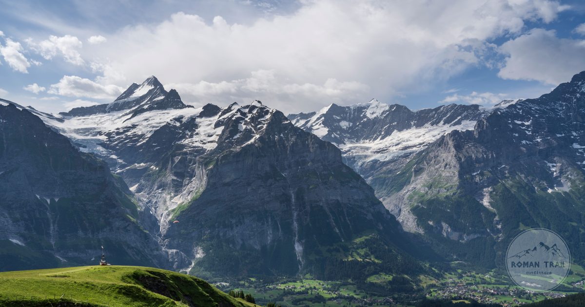 Panorama of the Swiss Alps in the Jungfrau region above green meadows, Grindelwald packing list for women by Roman Trail Outfitters