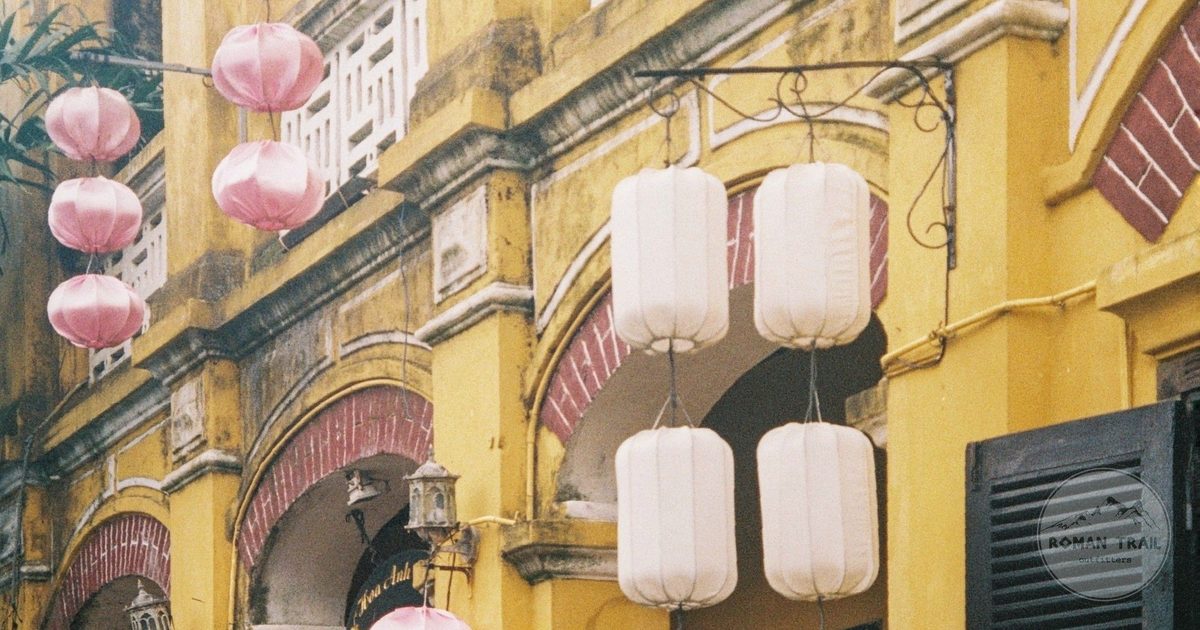 Silk lanterns hanging against the yellow washed wall of an Ancient Town merchant house, Hoi An for women travelers