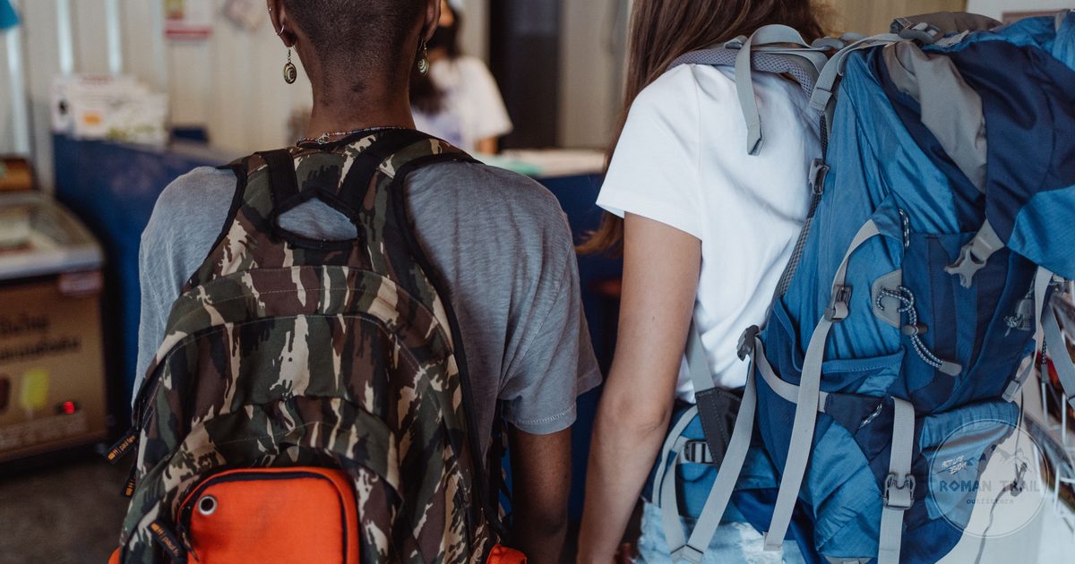 Two travellers with backpacks exploring indoors