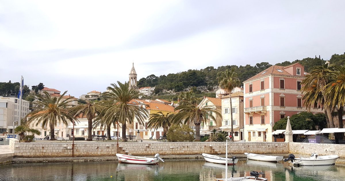 The harbour at Hvar with boats, historic buildings and palms, Croatia