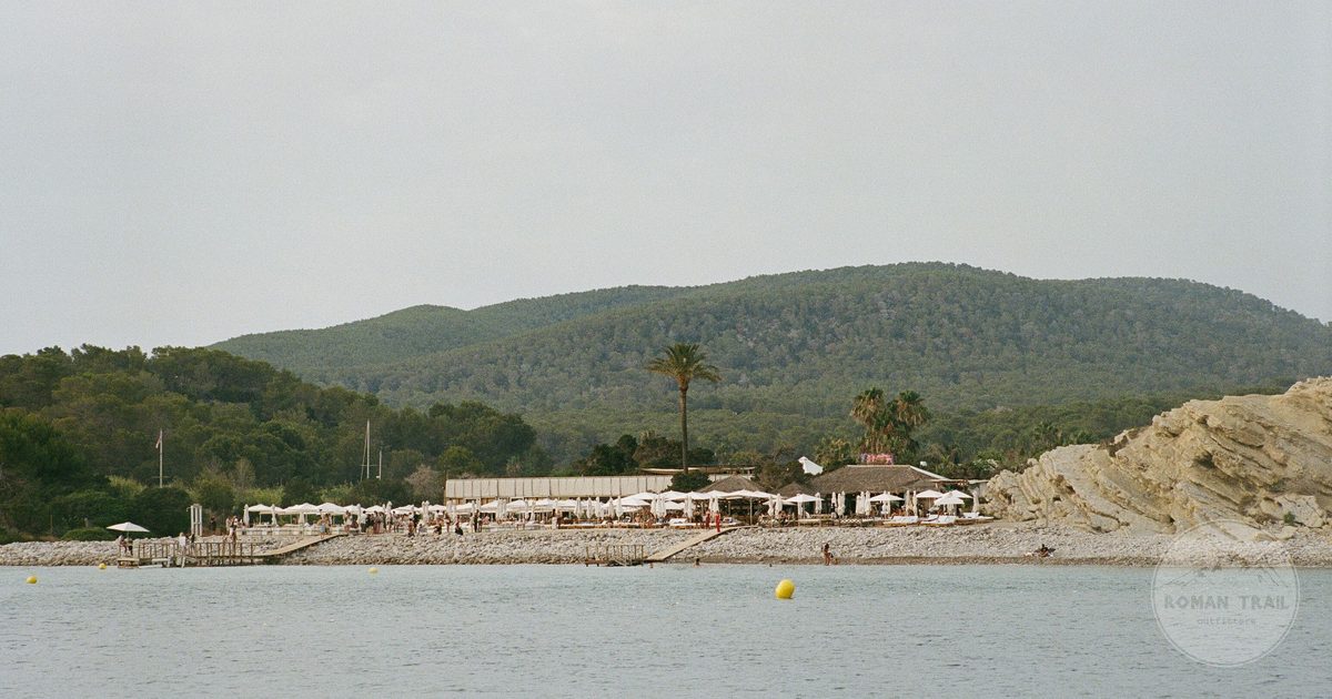 A quiet beach and green hills on the Ibiza coast, Ibiza packing list for women by Roman Trail Outfitters