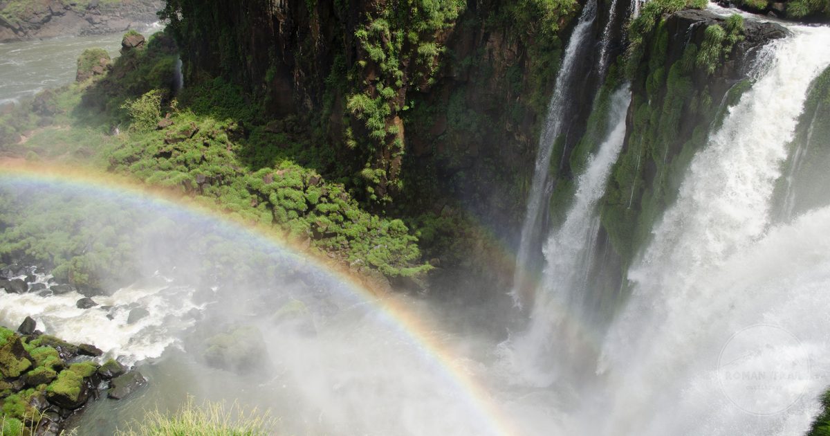 A rainbow over Iguazu Falls and the surrounding forest
