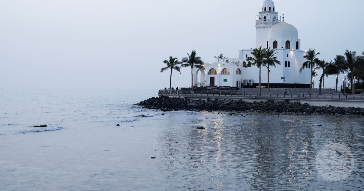 A seaside mosque with palm trees and calm water in Jeddah, Saudi Arabia