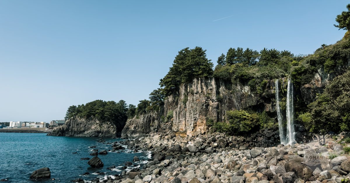Jeongbang waterfall on the rocky shore of Jeju Island, South Korea