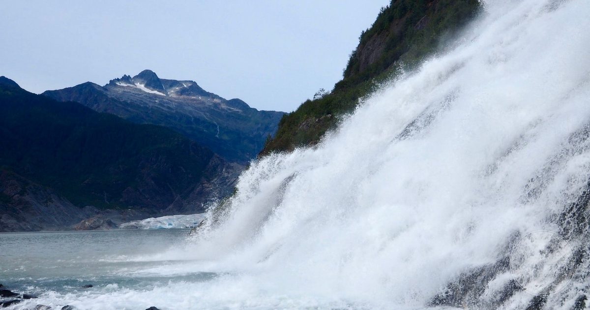 Nugget Falls cascading into the glacial lake at Mendenhall, Juneau